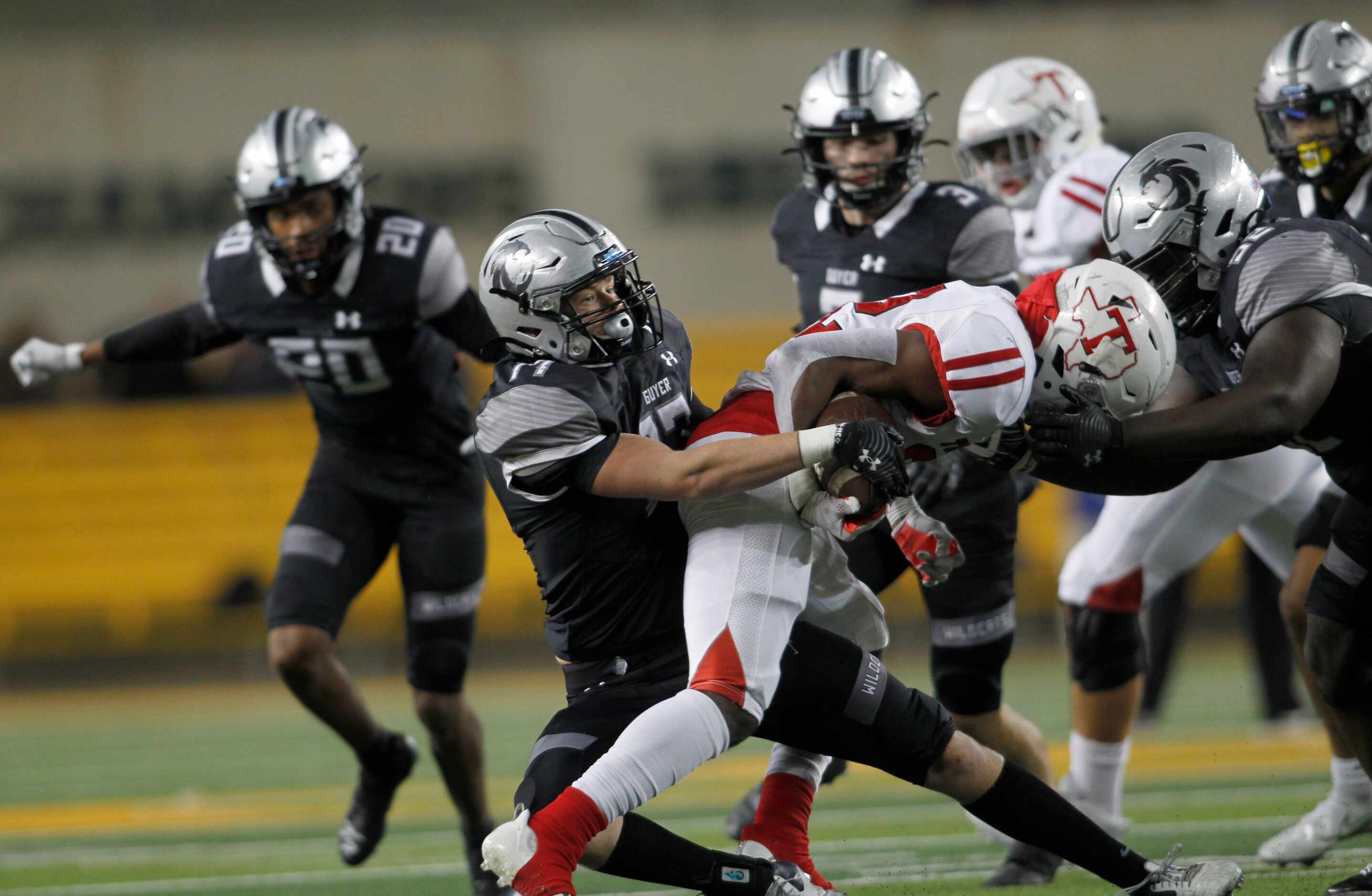 Denton Guyer linebacker Brooks Etheridge (17), center, strips the ball away from Tomball...