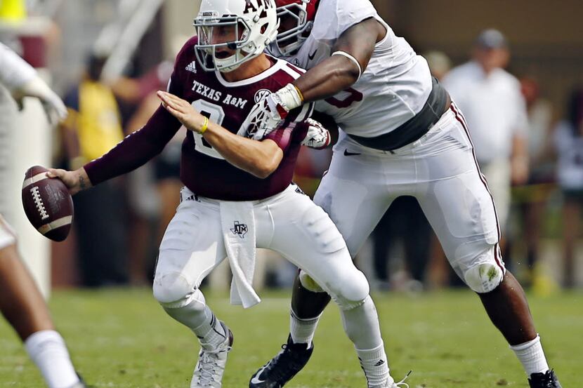 Texas AM Aggies quarterback Johnny Manziel (2) tries to evade a tackle by Alabama Crimson...