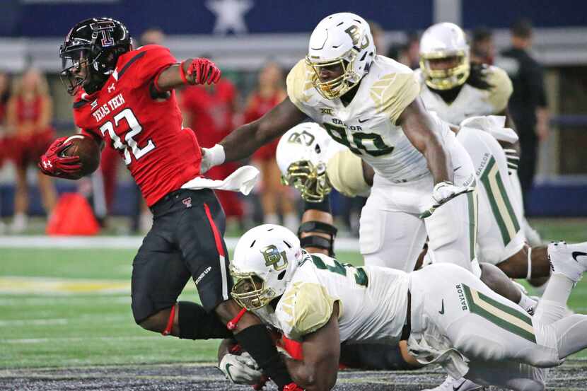 A host of Baylor defenders combine to stop Texas Tech  running back Da'Leon Ward (32) on a...
