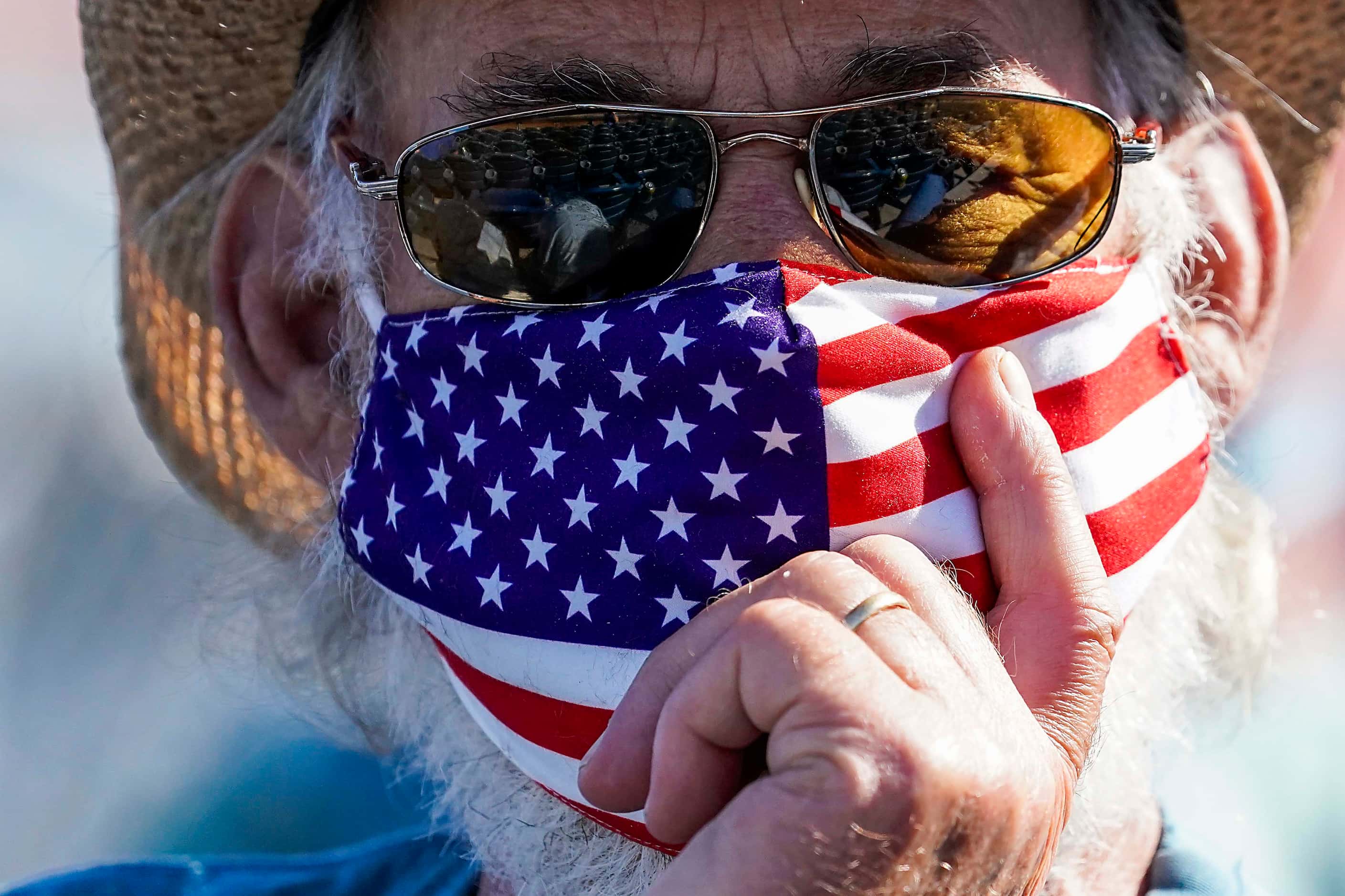 A fan wears an American flag face covering during the fourth inning of a spring training...