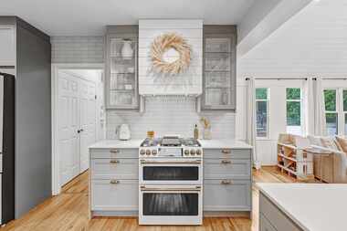 Updates to the home include a contemporary kitchen with gray countertops and a refrigerator,...
