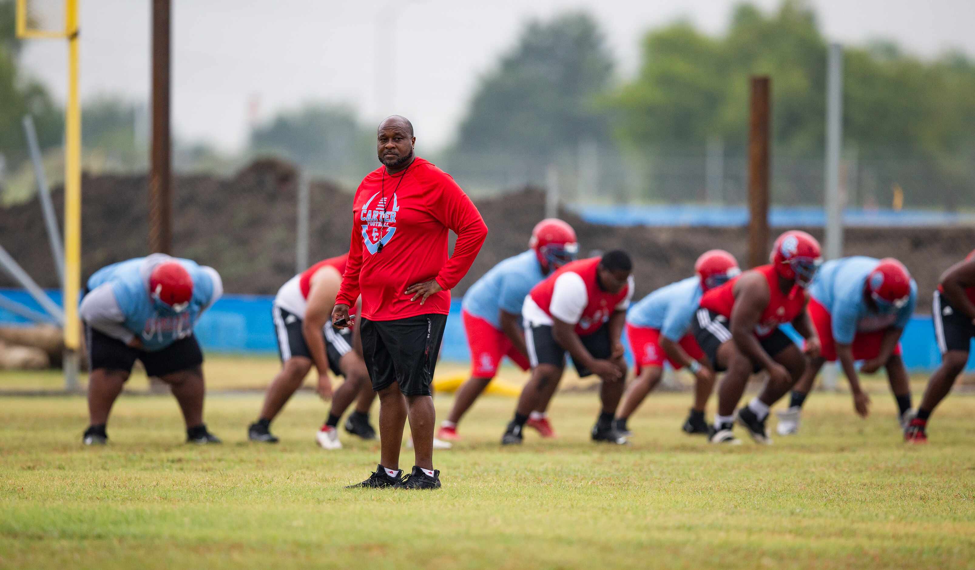 Carter head coach Spencer Gilbert watches his team during the first day of football practice...