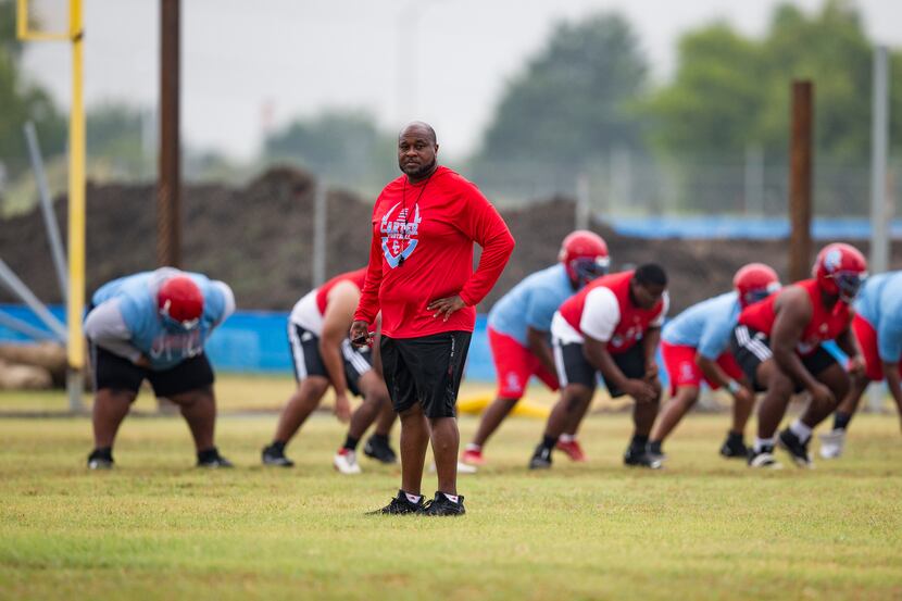 Carter head coach Spencer Gilbert watches his team during the first day of football practice...