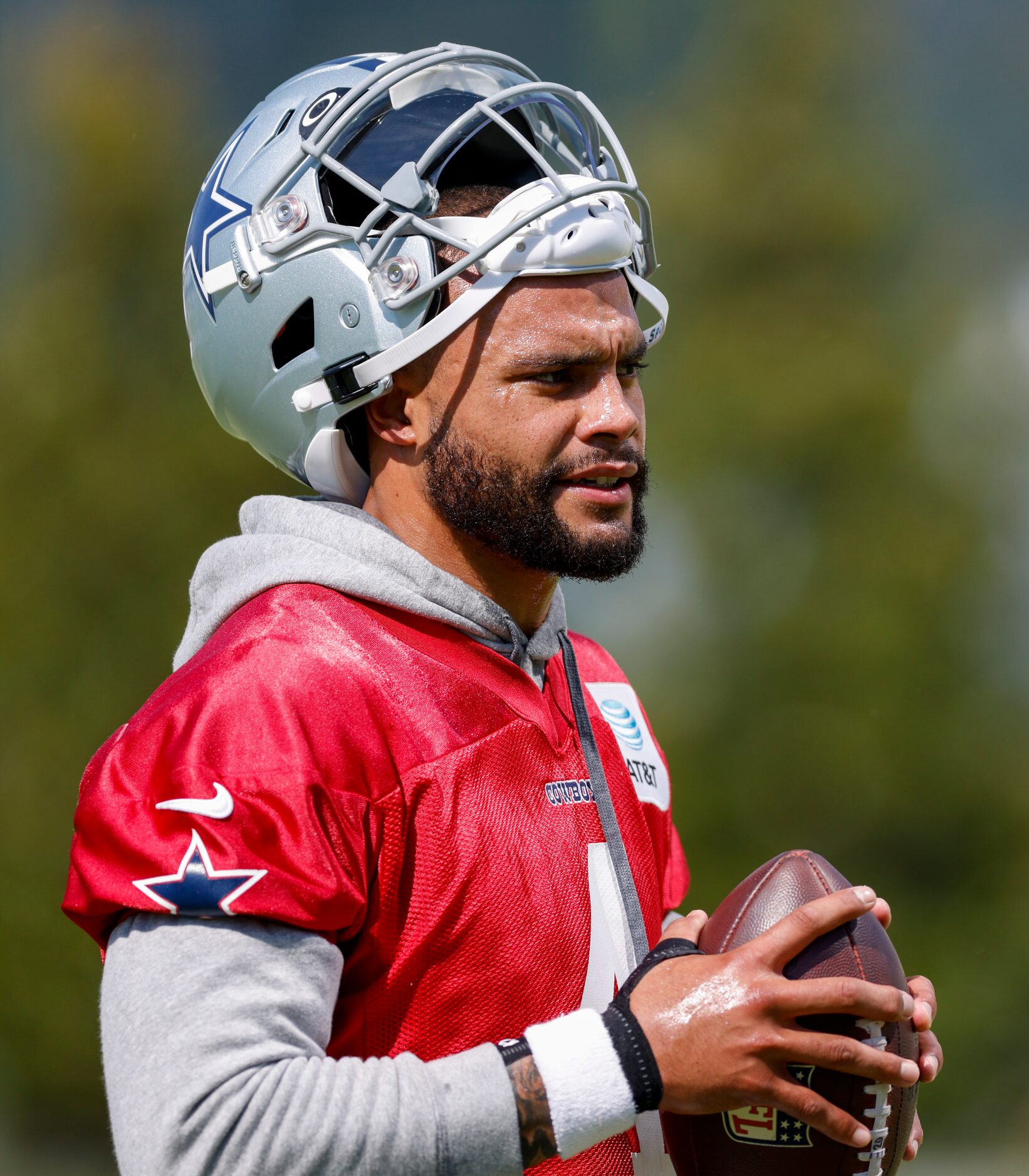 Dallas Cowboys quarterback Dak Prescott (4) holds a ball while wearing a brace on his...