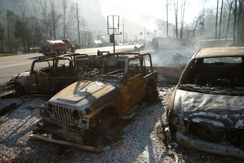 The remains of a Jeep rental business smolders after a wildfire November 29, 2016 in...