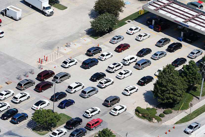 Lines of cars waiting to pump gas stretch into the parking lot Thursday at the Costco store...