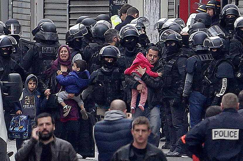
A family is escorted away from the site of the raid in Saint-Denis. Investigators found...