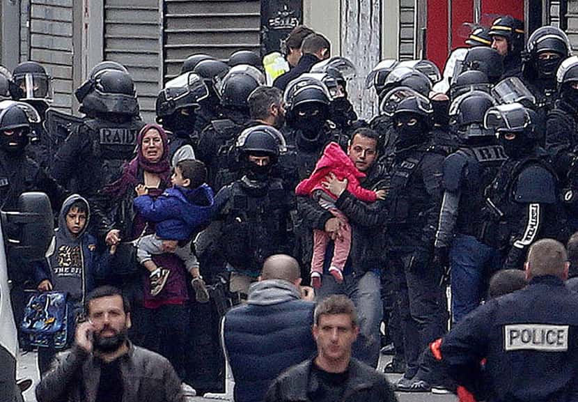 
A family is escorted away from the site of the raid in Saint-Denis. Investigators found...