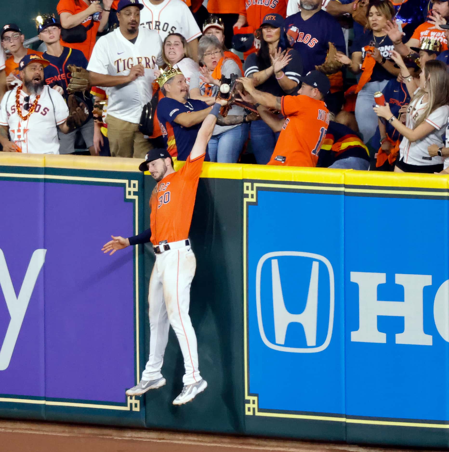 Houston Astros right fielder Kyle Tucker (30) goes up against the wall to steal a home run...