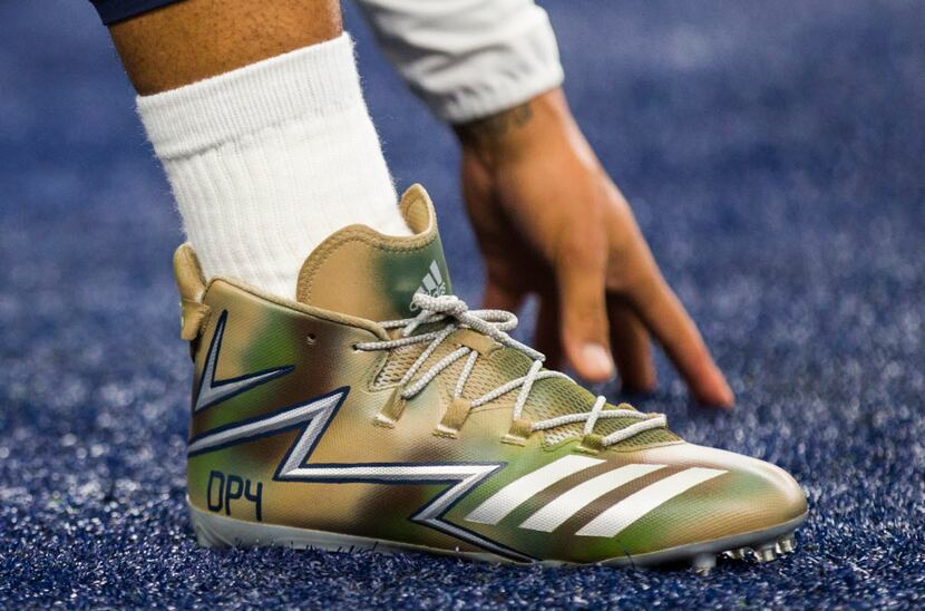 Dallas Cowboys quarterback Dak Prescott (4) wears custom camp shoes as he warms up before an...