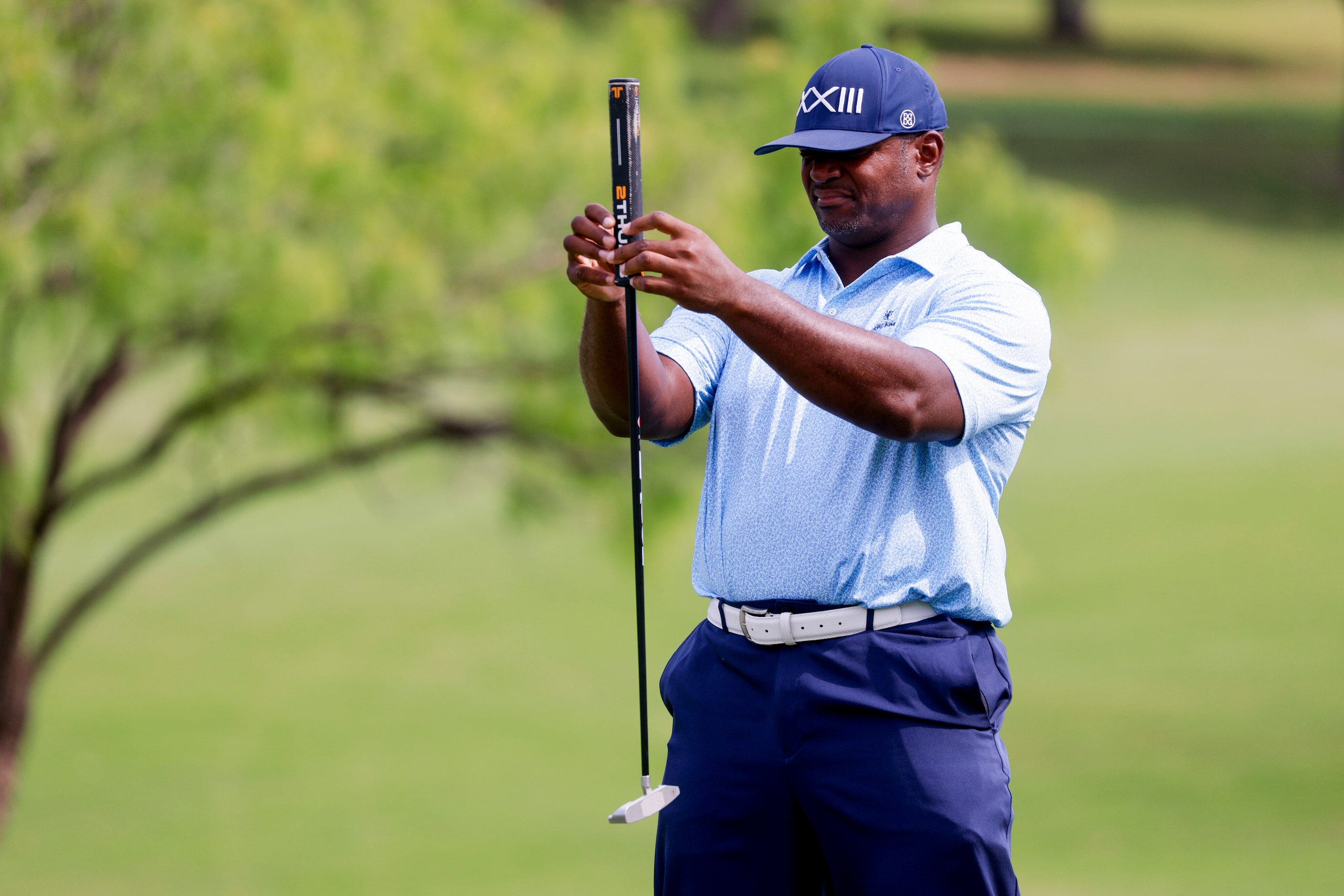 Pro Football Hall of Famer Dwight Freeney lines up his shot on the 14th green during the...