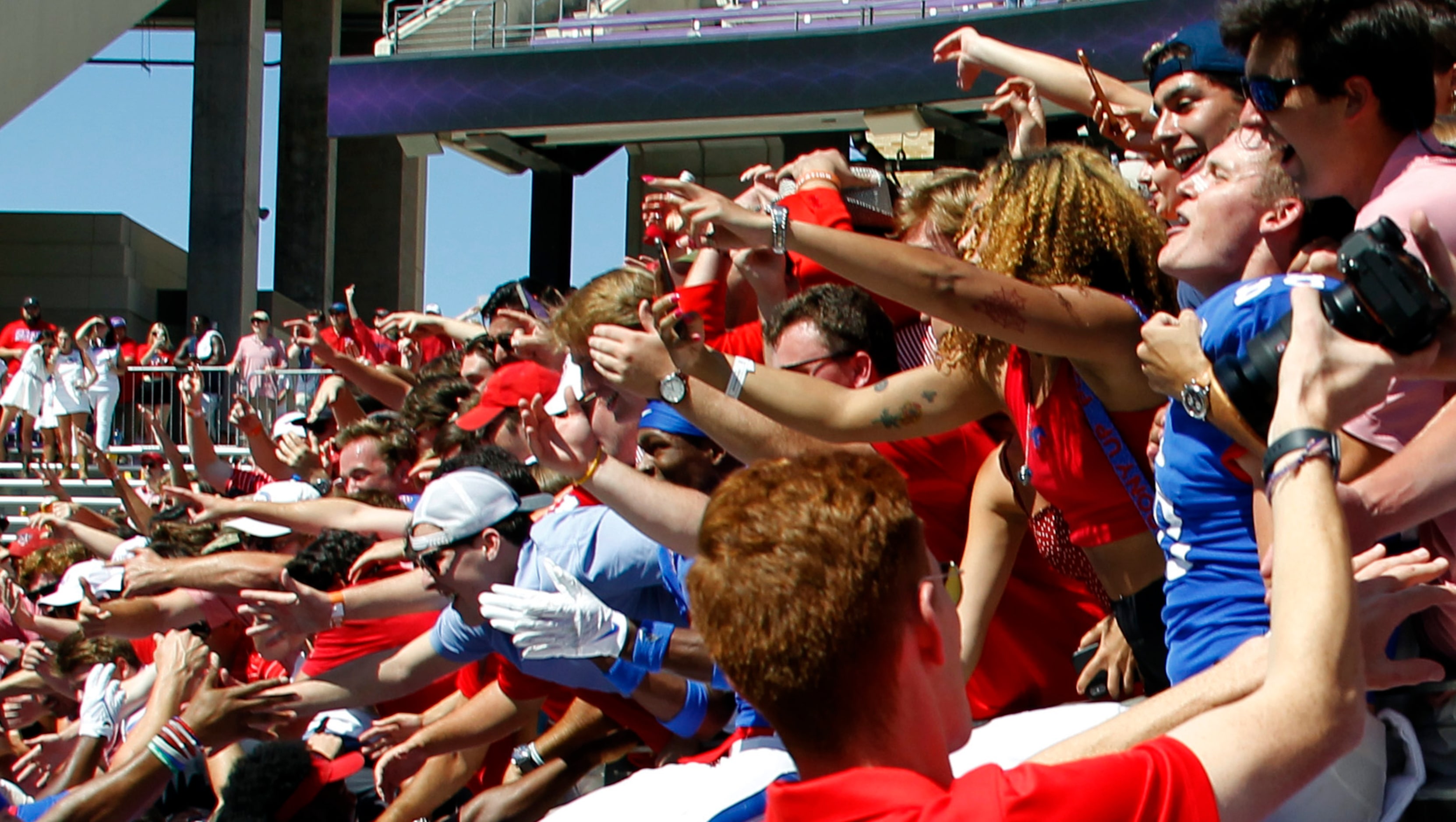 SMU tight end Grant Calcaterra (88), far right, lets out a howl after Mustangs fans helped...