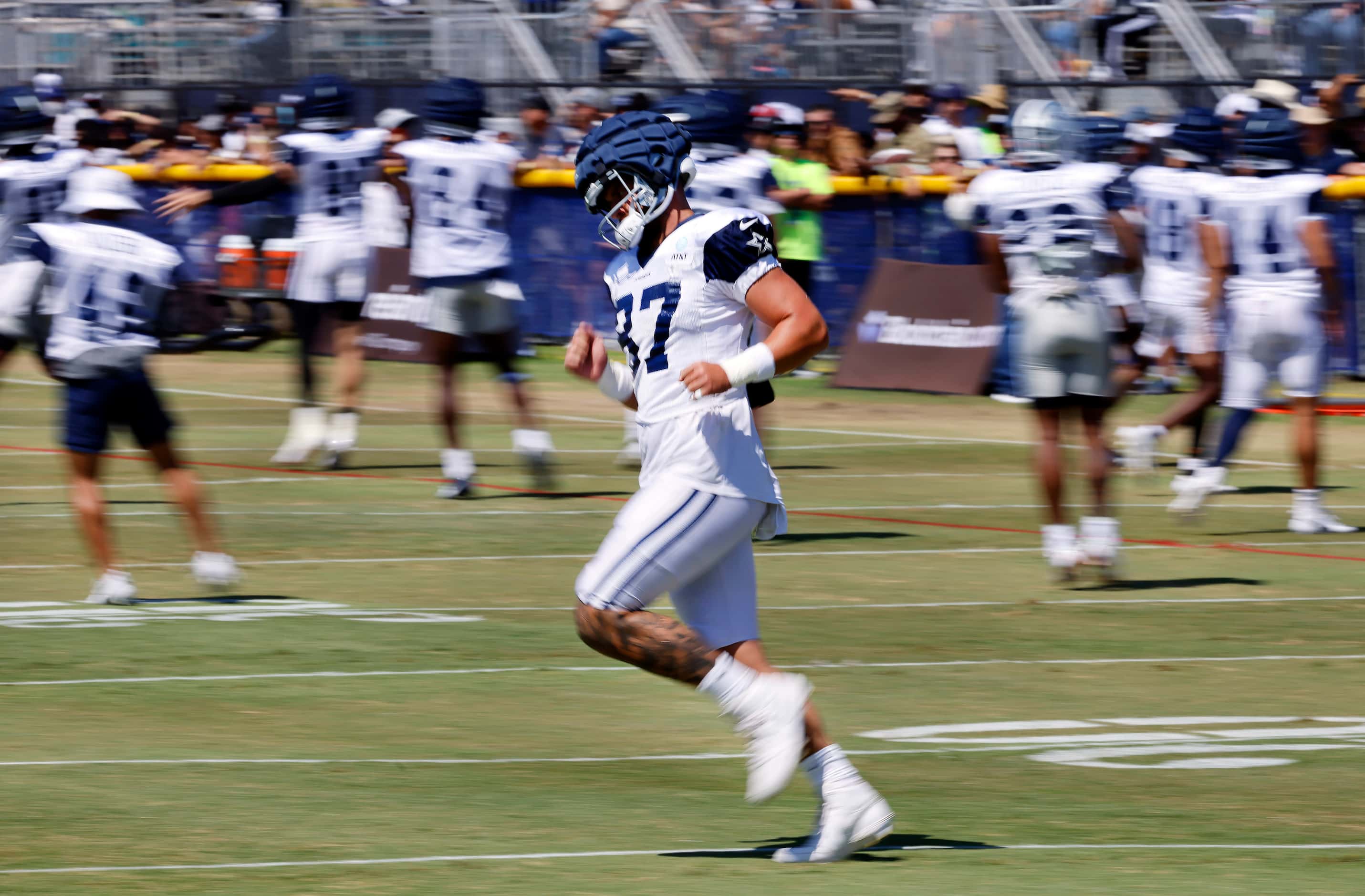 Dallas Cowboys tight end Jake Ferguson (87) stretches before training camp practice begins...