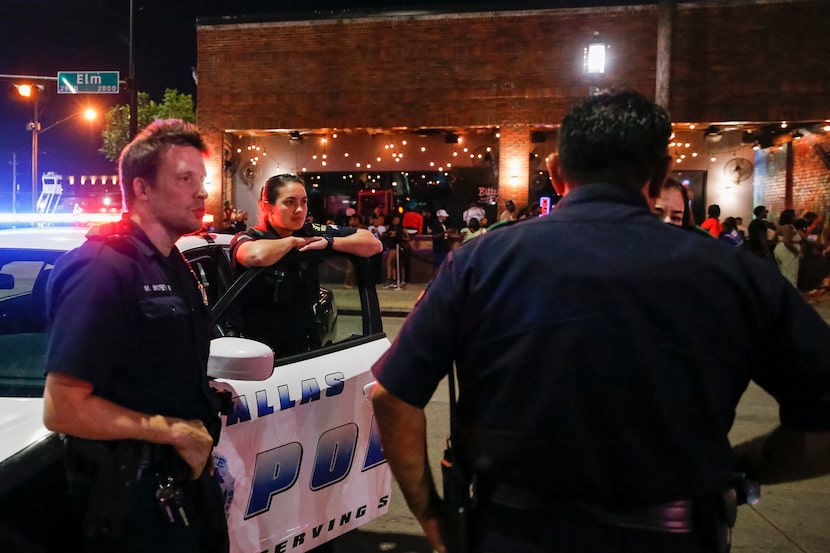 Dallas Police officers stand on patrol on Elm Street in Deep Ellum.