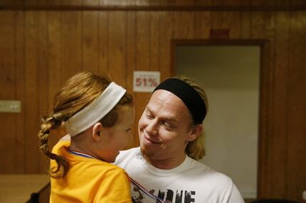 Professional wrestler Andy Dalton of Irving holds his 5-year-old daughter, Mia, before he...