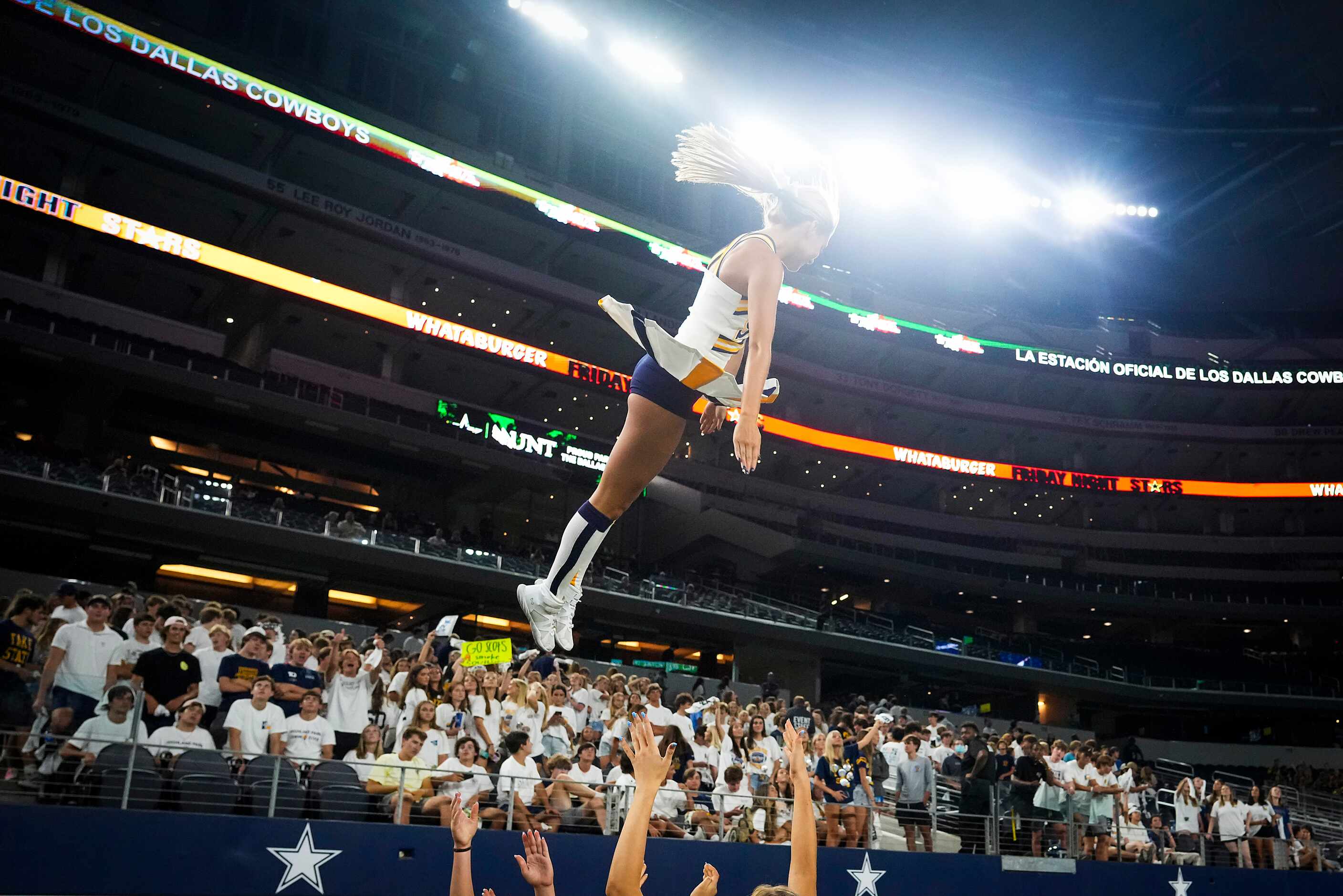 A Highland Park cheerleader is tossed into the air during the second half of a high school...