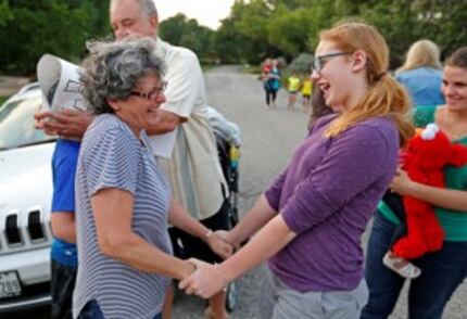  Kate Kendrick (right), 12, shares a laugh with Joan Tober after the Kendrick family arrived...