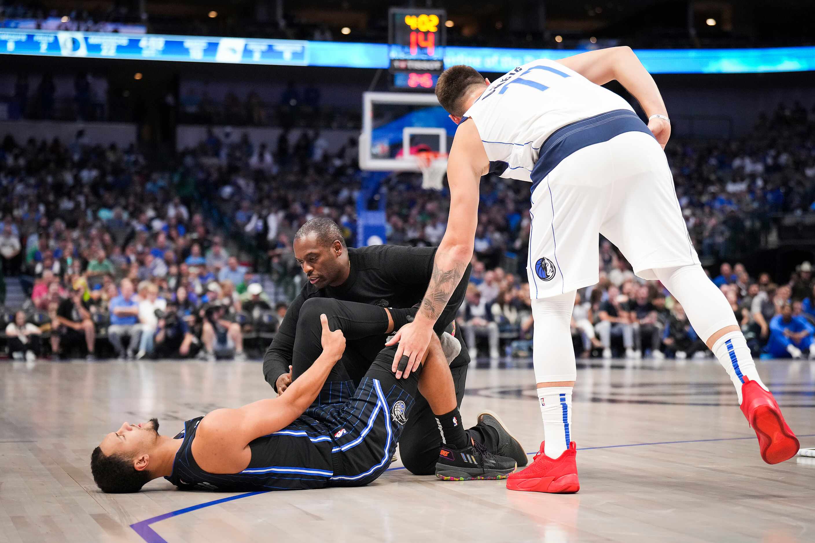 Dallas Mavericks guard Luka Doncic (77) checks on Orlando Magic guard Jalen Suggs (4) after...
