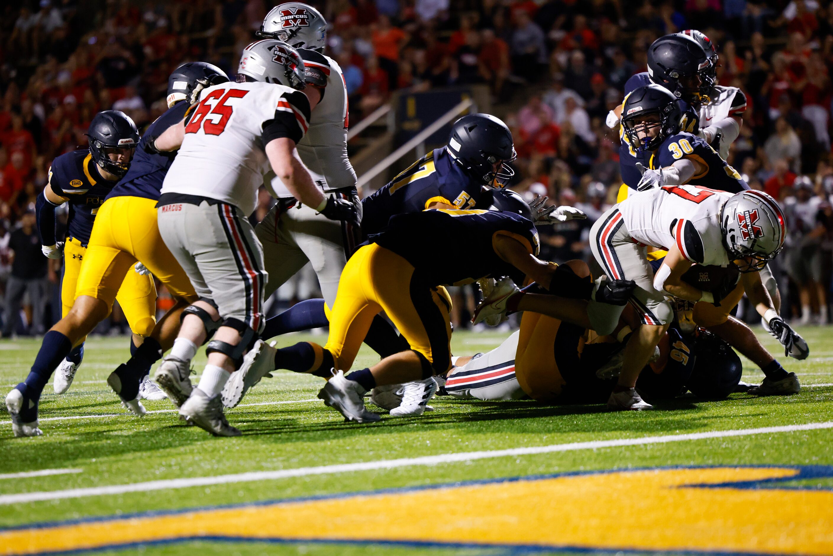 Flower Mound Marcus running back Chance Banner (27) breaks through the Highland Park...