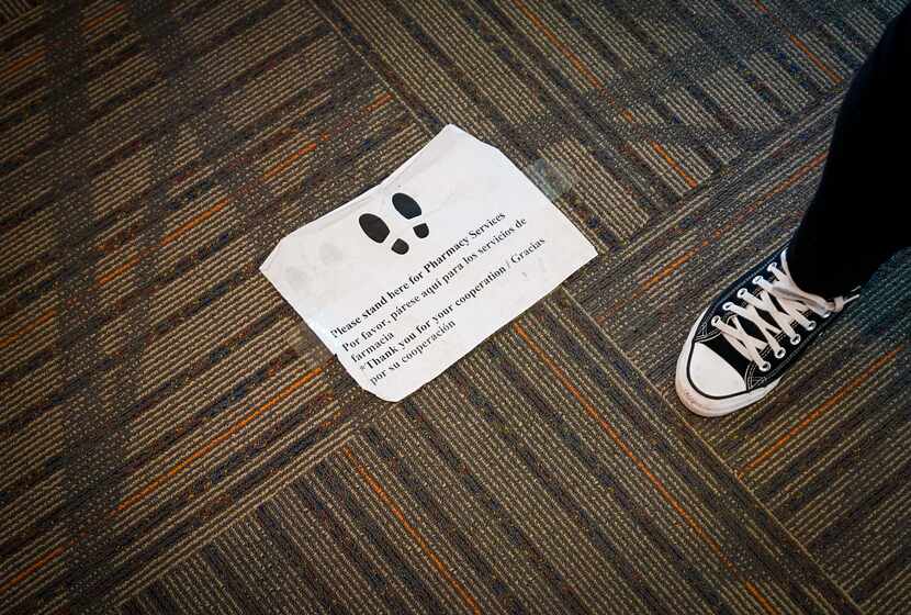 A sign on the floor instructed clients where to wait outside the doorway to fill...
