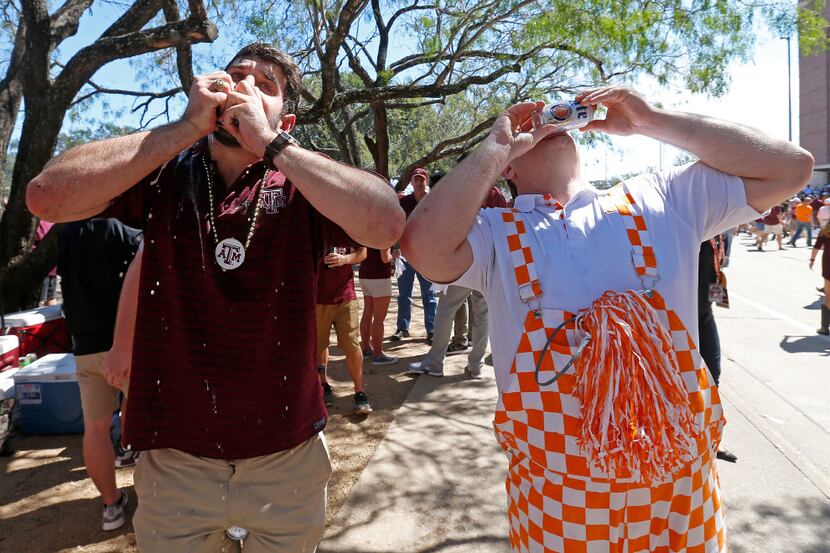 Texas A&M fan Jarrett Bennett (left) and Tennessee fan Chris Turner drink beer prior to the...