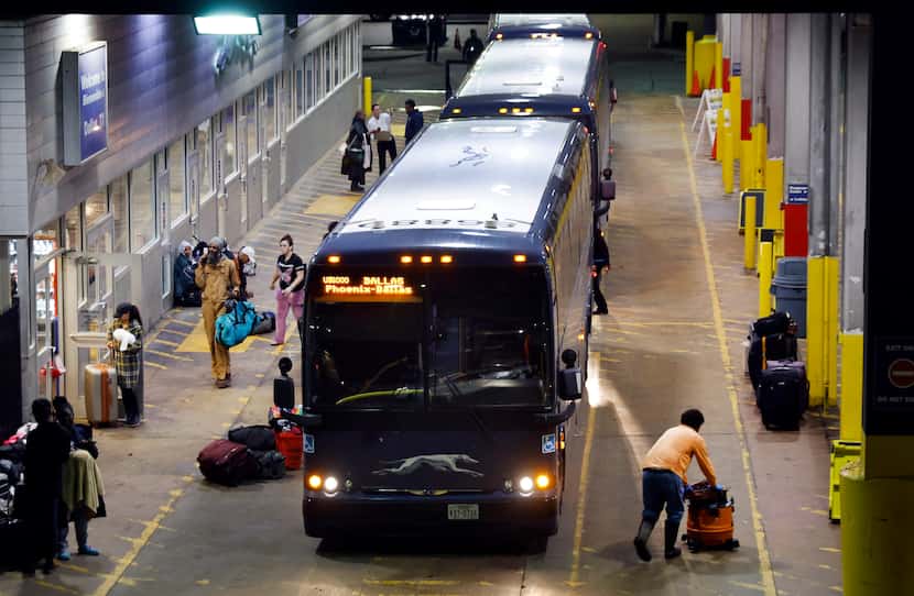 Passengers get off a Greyhound bus at the station on S Lamar St in downtown Dallas, January...