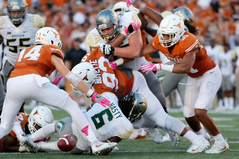 Baylor running back JaMycal Hasty (6) fumbles the ball after being tackled by Texas...