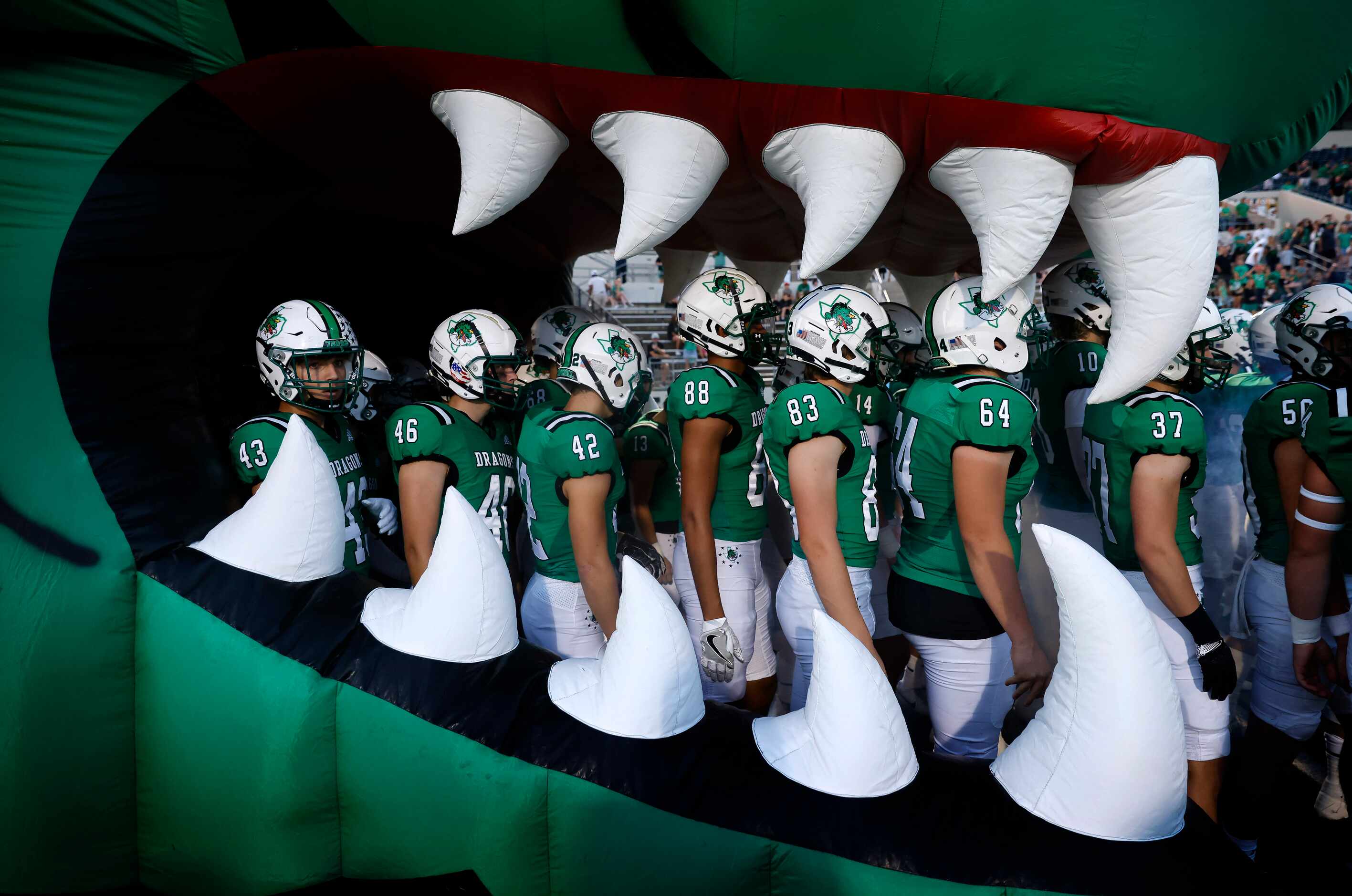 The Southlake Carroll football team waits inside the  Dragon mascot inflatable to be...