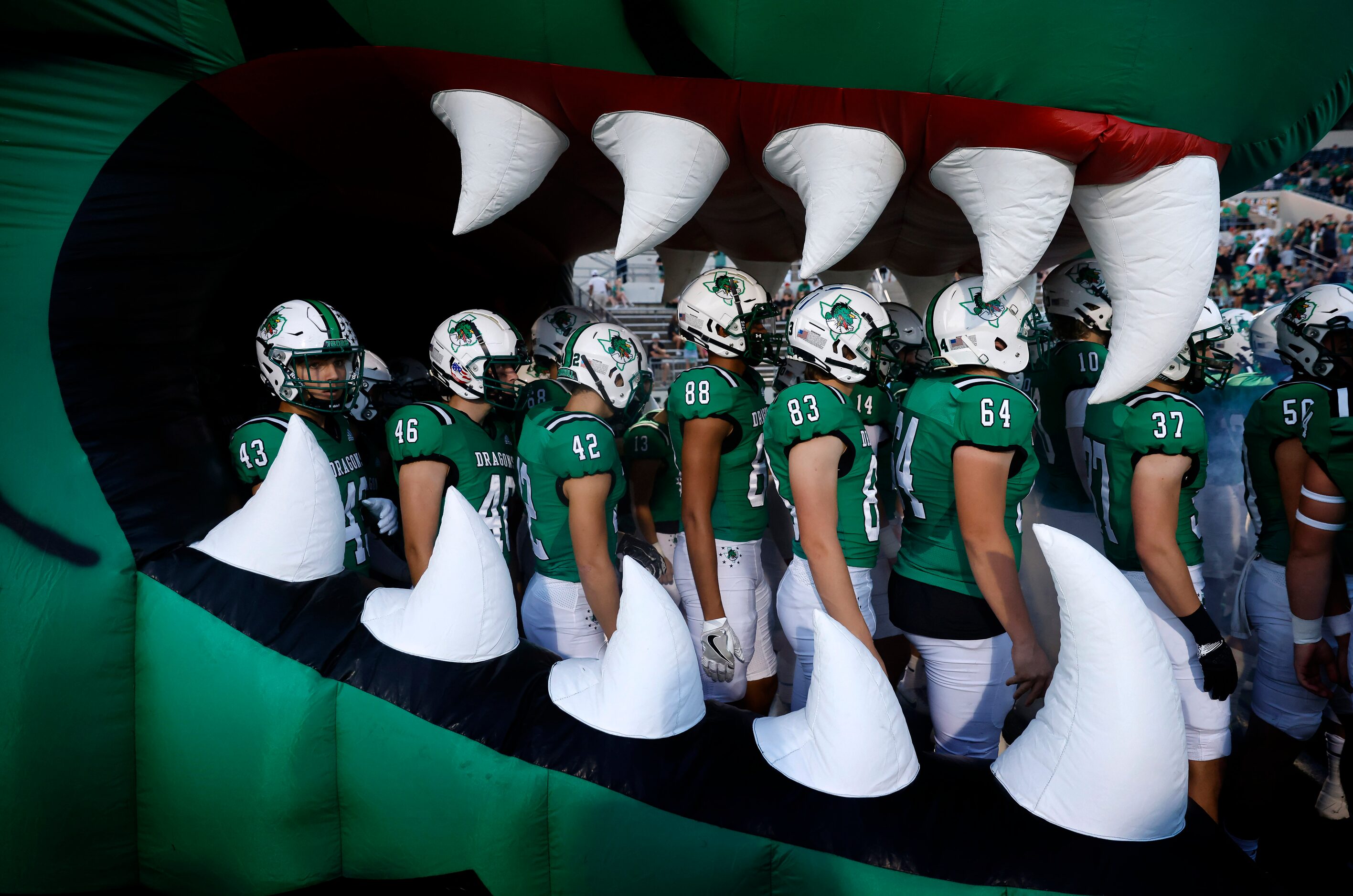 The Southlake Carroll football team waits inside the  Dragon mascot inflatable to be...