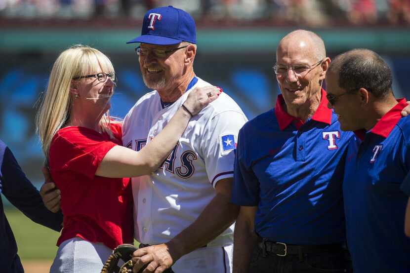 Texas Ranger coach Bobby Jones gets a hug from his daughter Jill Jones after throwing out a...