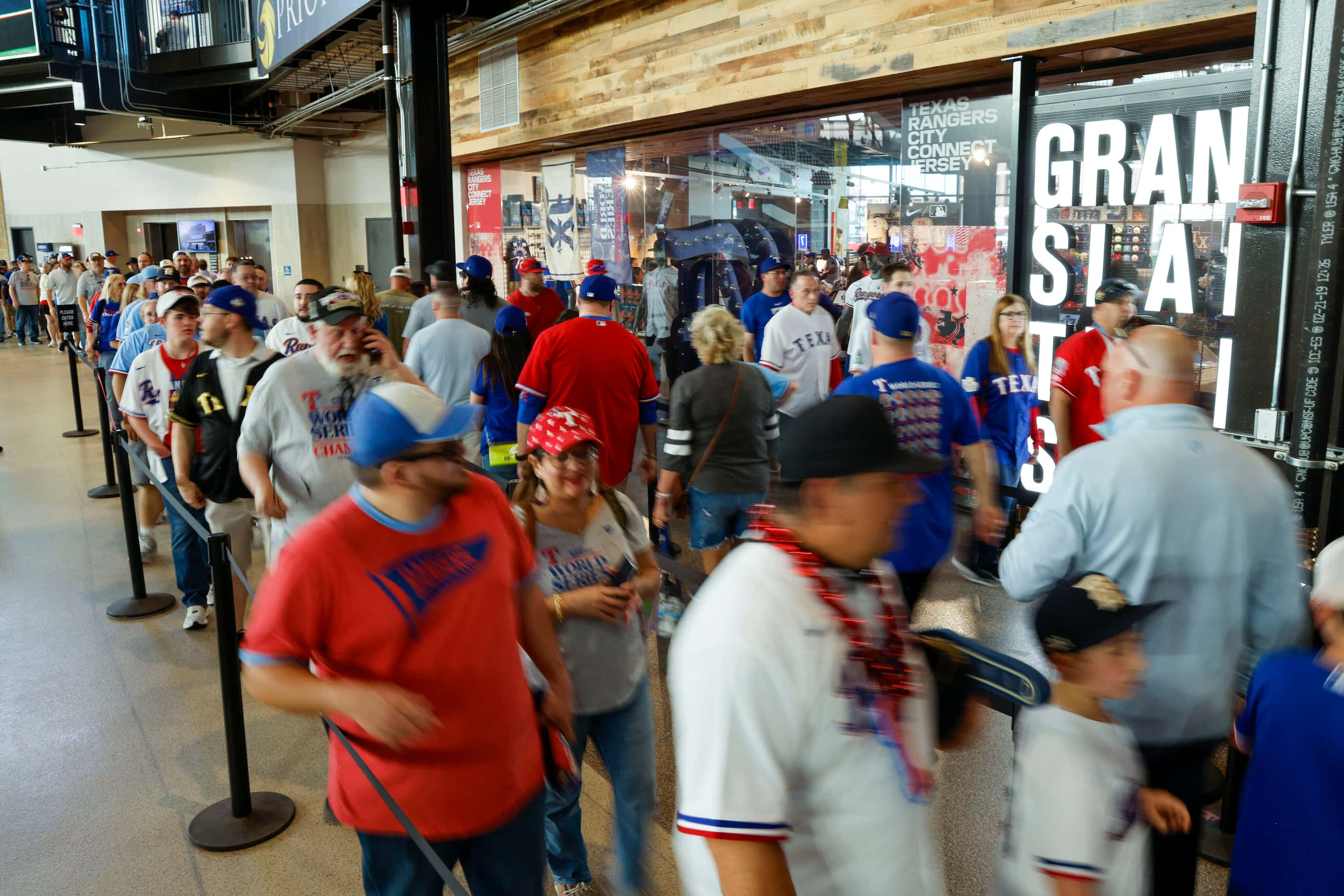 Dozens of Texas Rangers fans move through a line to enter the Grand Slam Team Store before...
