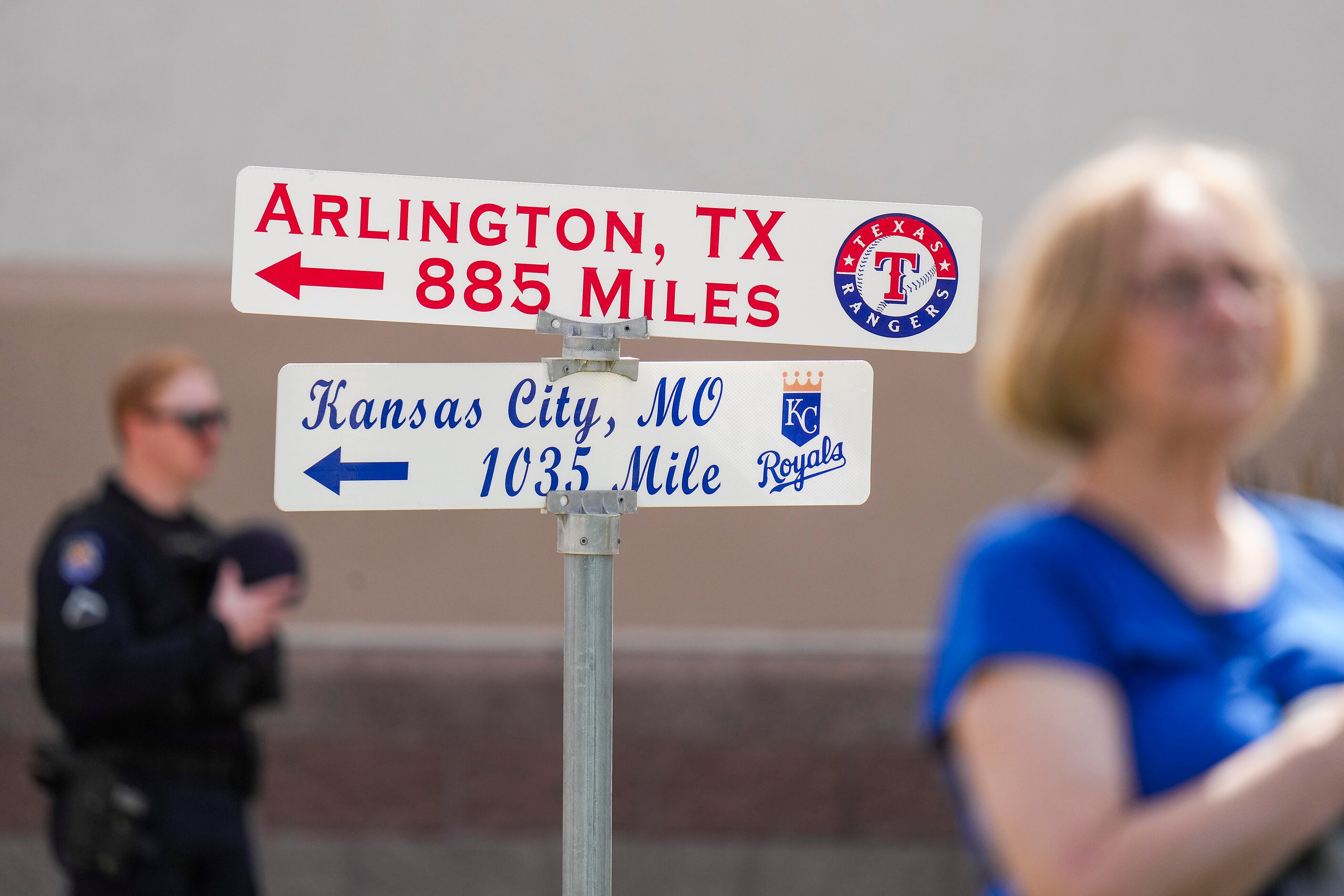 Fans and security stand for the national anthem near a sign showing the distance to...