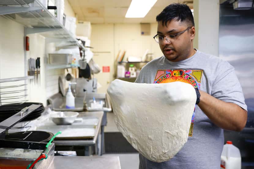 SauceBros Pizza co-owner Redwan Huda prepares the dough as he works on a pizza on Thursday,...