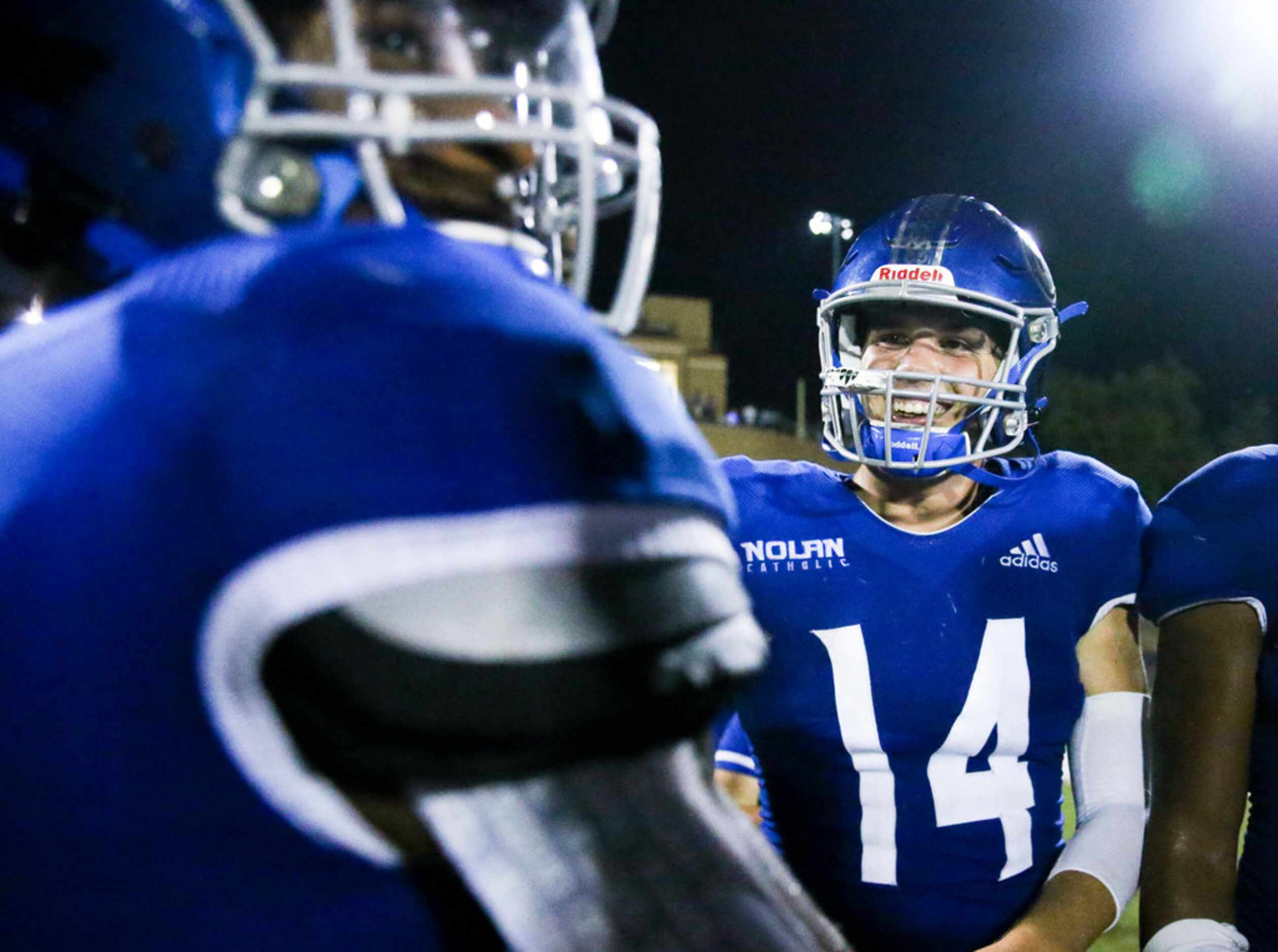 Nolan Catholic quarterback Jummy Taylor (14) celebrates with running back Emeka Megwa (6)...