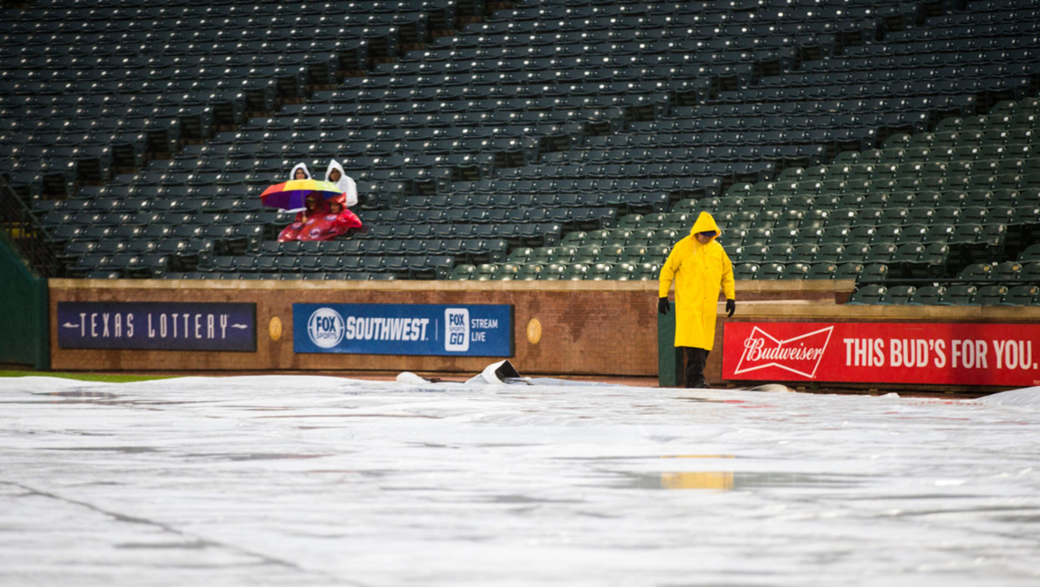 Texas Rangers fans wait in the rain before an MLB game between the Texas Rangers and the...