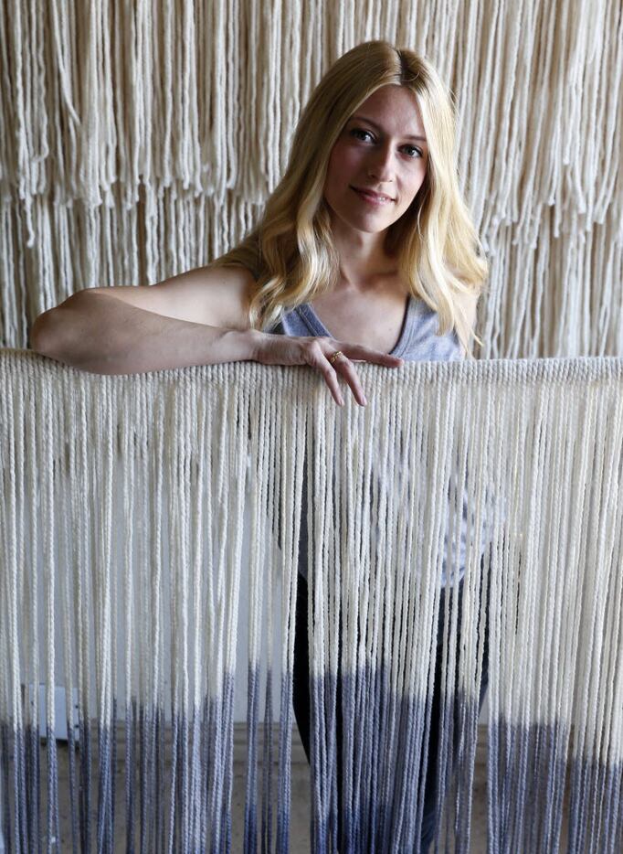 Artist Lauren Williams poses for a portrait next to a tapestry she made at her home in...