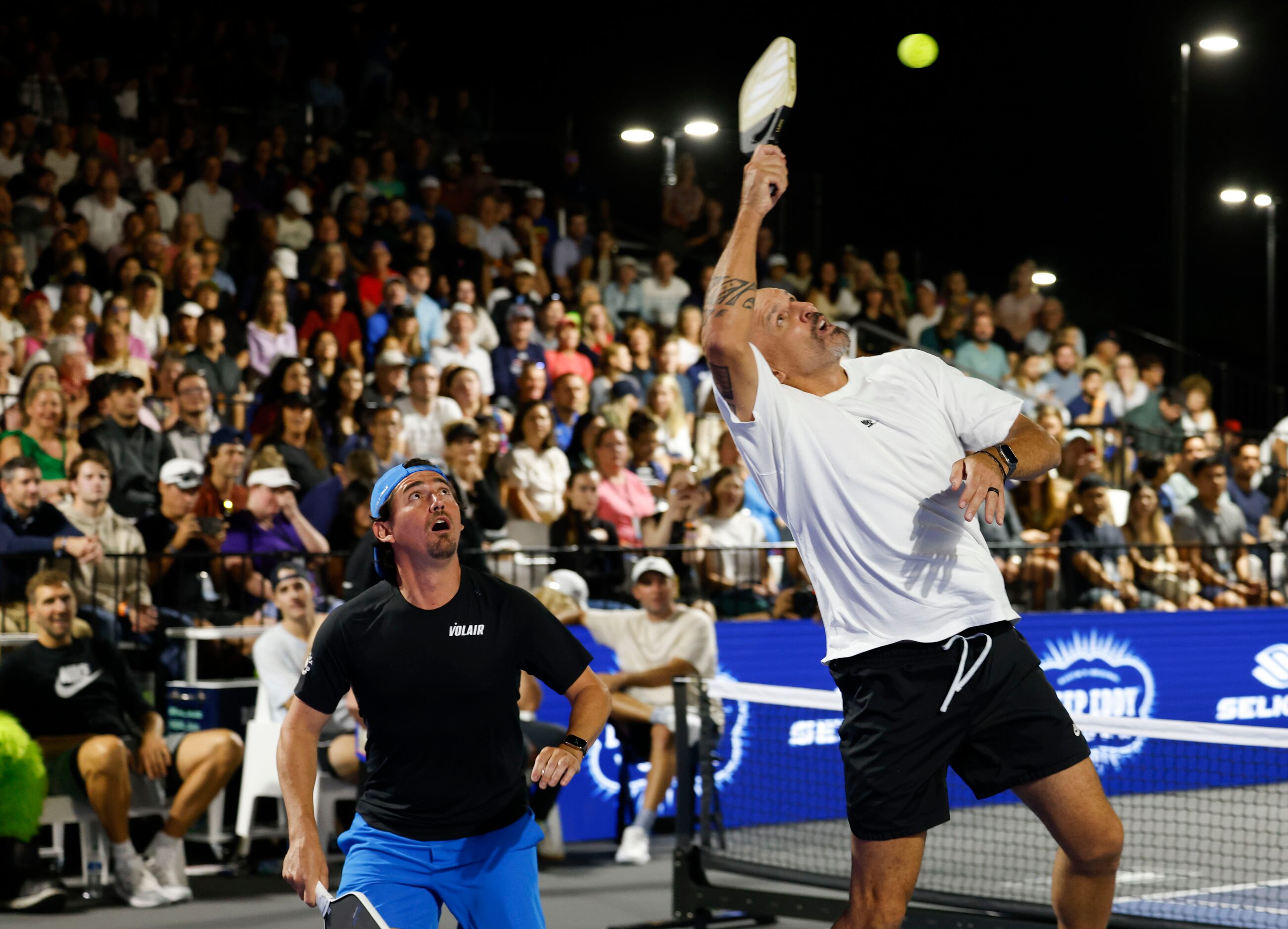 Professional pickle ball player Julian Arnold (left) watches as Dallas Mavericks head coach...