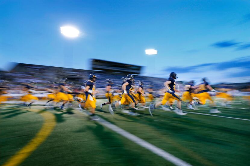 Highland Park football players race onto the field as they are introduced to the hometown...
