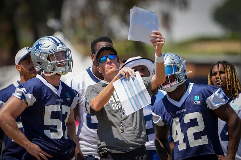 El entrenador de equipos especiales de los Cowboys de Dallas, John Fassel (centro), revisa...