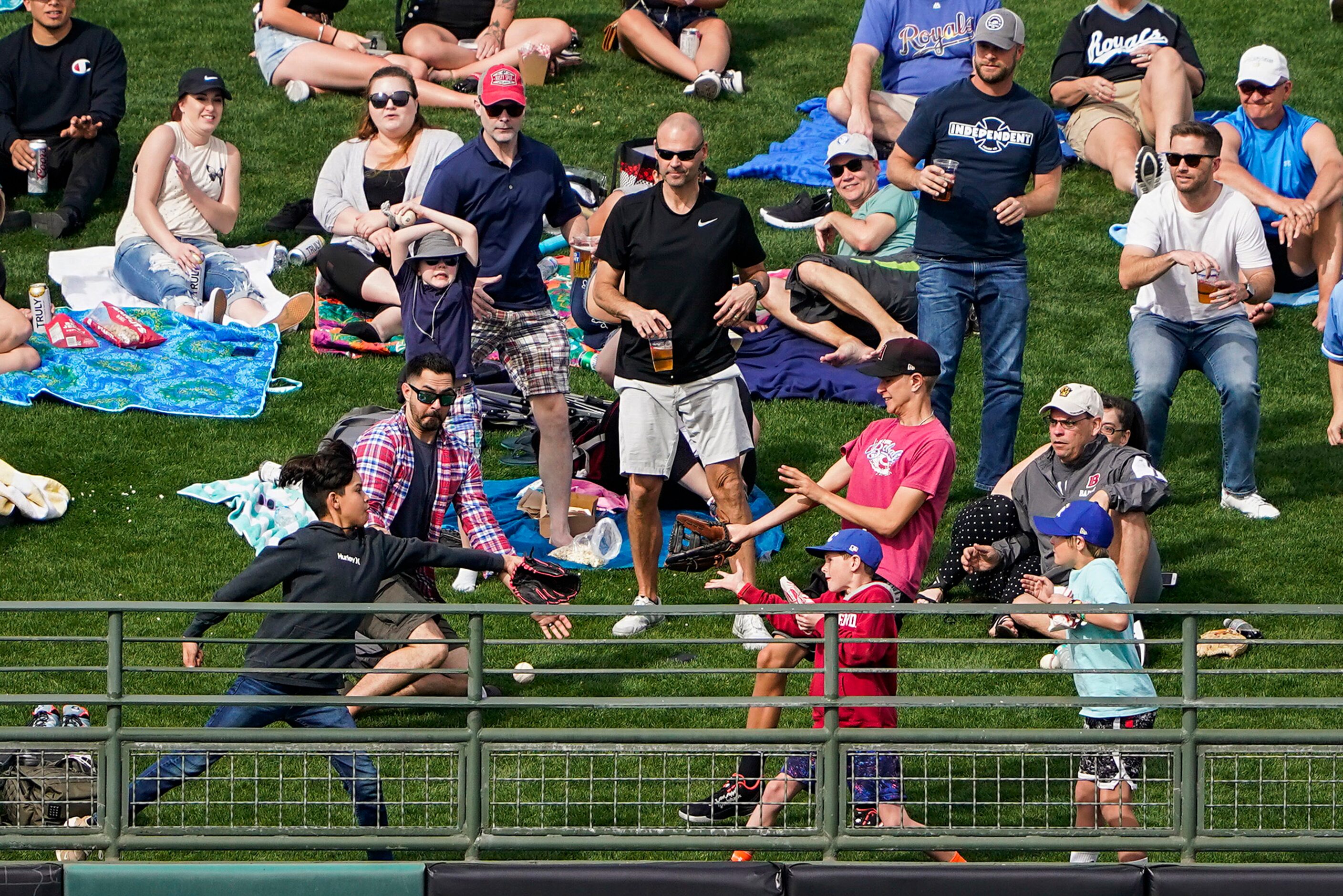 Fans try to catch the ball as a 2-run home run by Texas Rangers outfielder Rob Refsnyder...