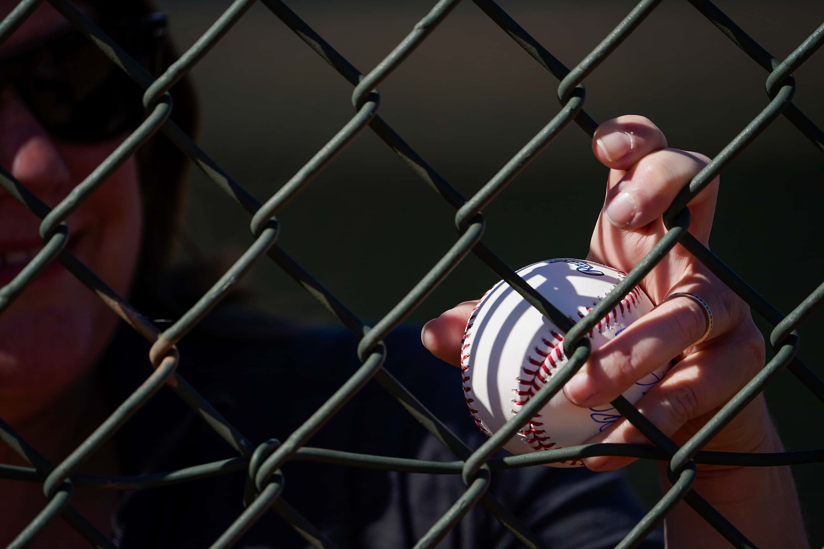 A fan holds a ball while waiting for autographs during a Texas Rangers spring training...