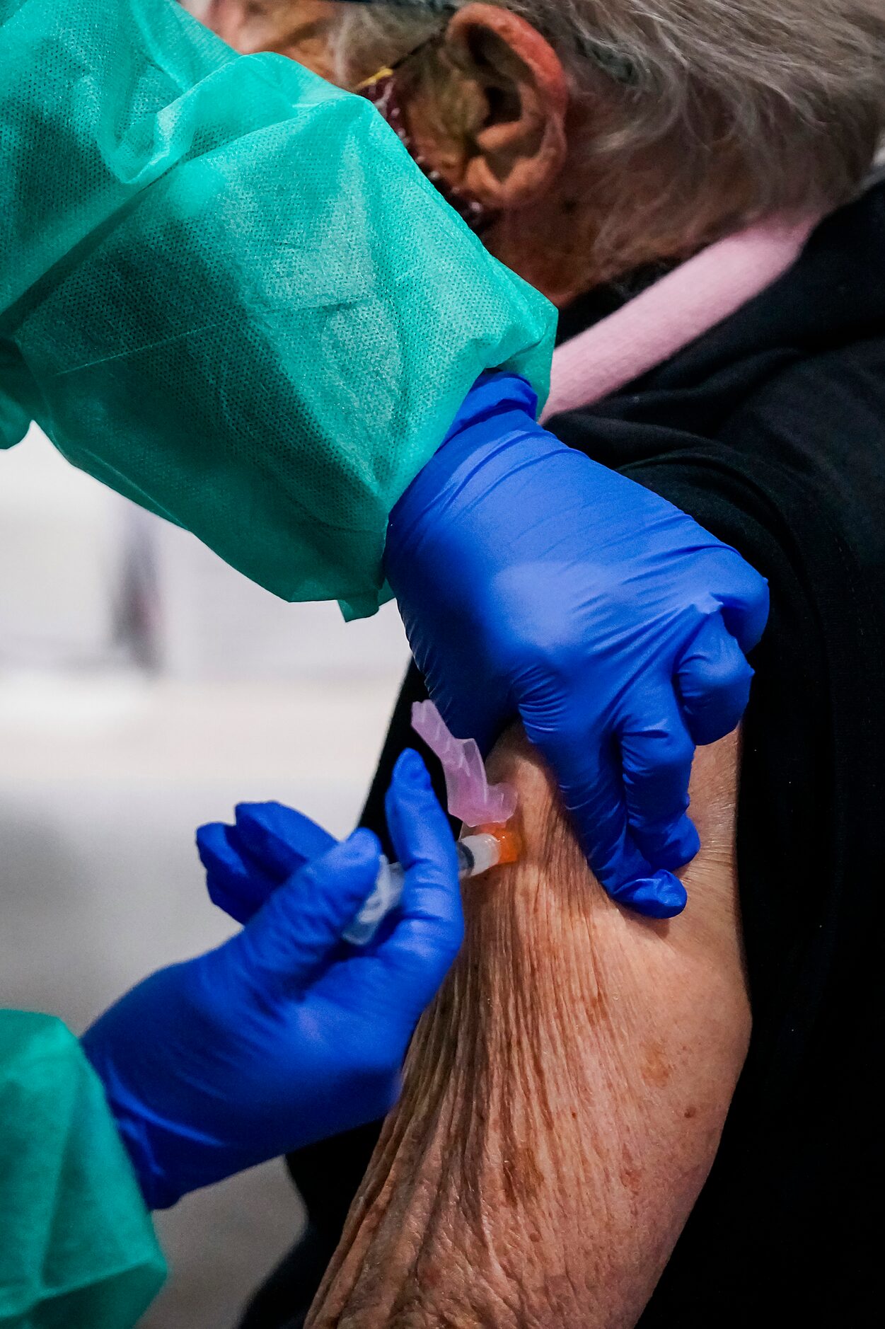 An Irving firefighter administers the COVID-19 vaccine to woman at Fair Park on Monday, Jan....