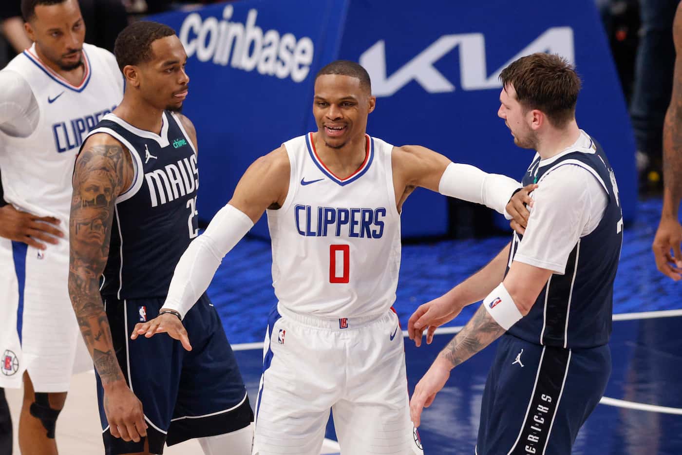LA Clippers guard Russell Westbrook (0) pushes Dallas Mavericks guard Luka Doncic (77)...