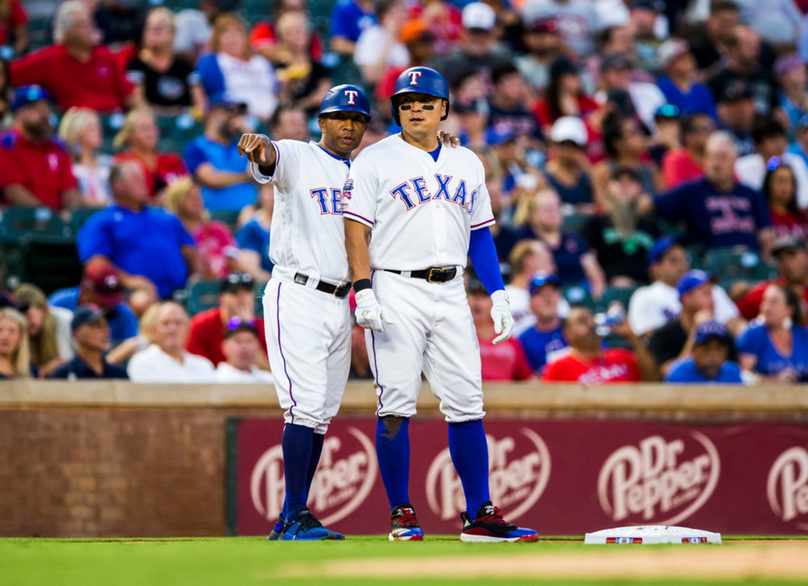 Texas Rangers third base coach Tony Beasley (37) coaches right fielder Shin-Soo Choo (17) at...