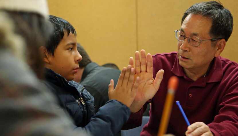 University of Texas at Dallas professor Gil Sik Lee (right) high-fives Jonathan Mesa, 10,...