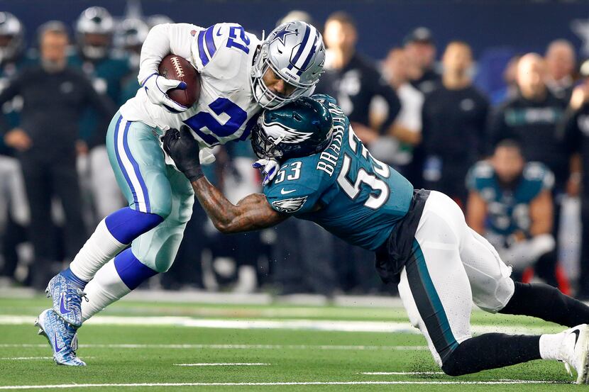 Dallas Cowboys running back Ezekiel Elliott (21) tries to escape the grasp of Philadelphia...