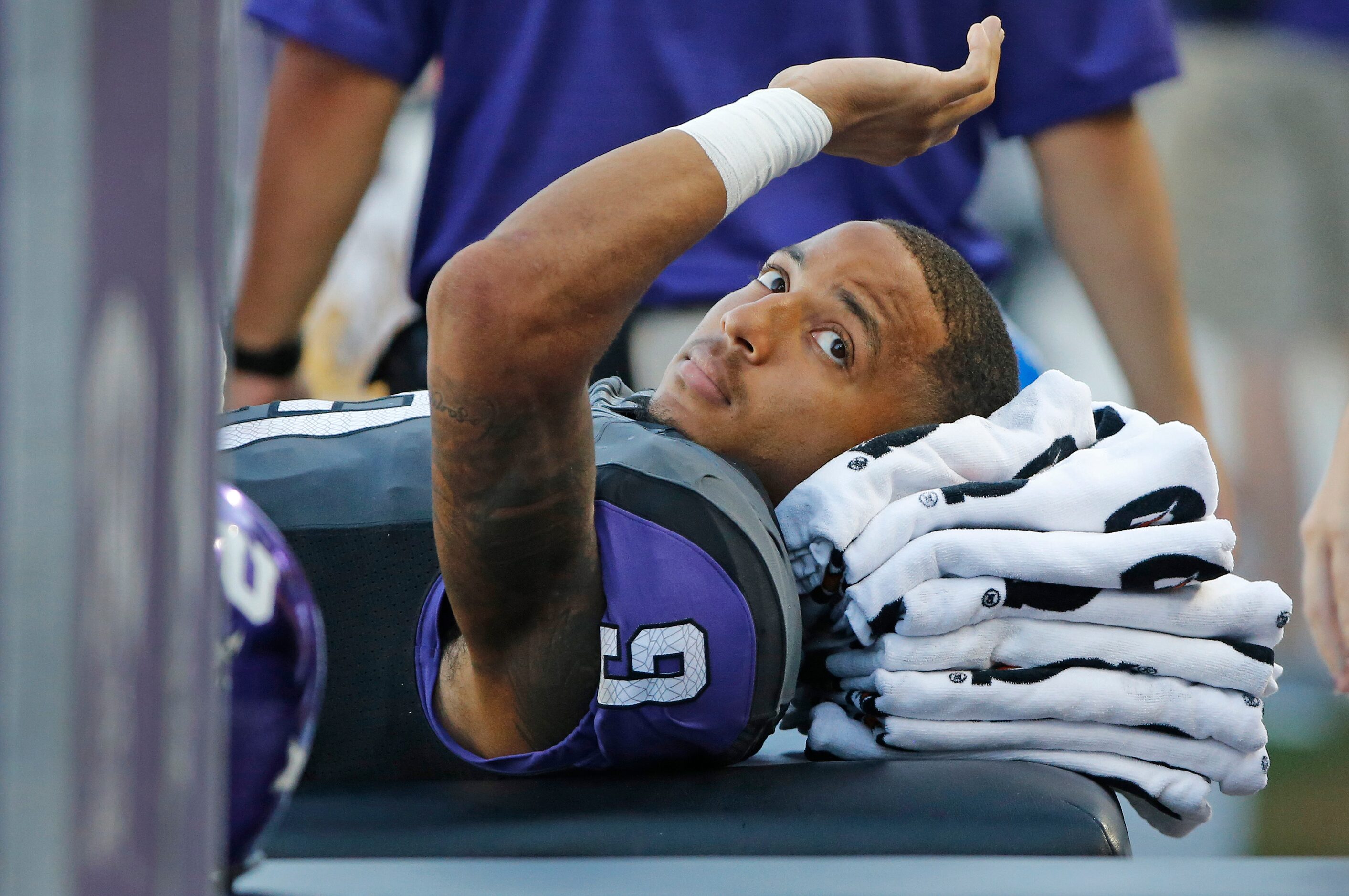 TCU receiver Josh Doctson (9) waves to a friend as he reclines on the sidelines after being...