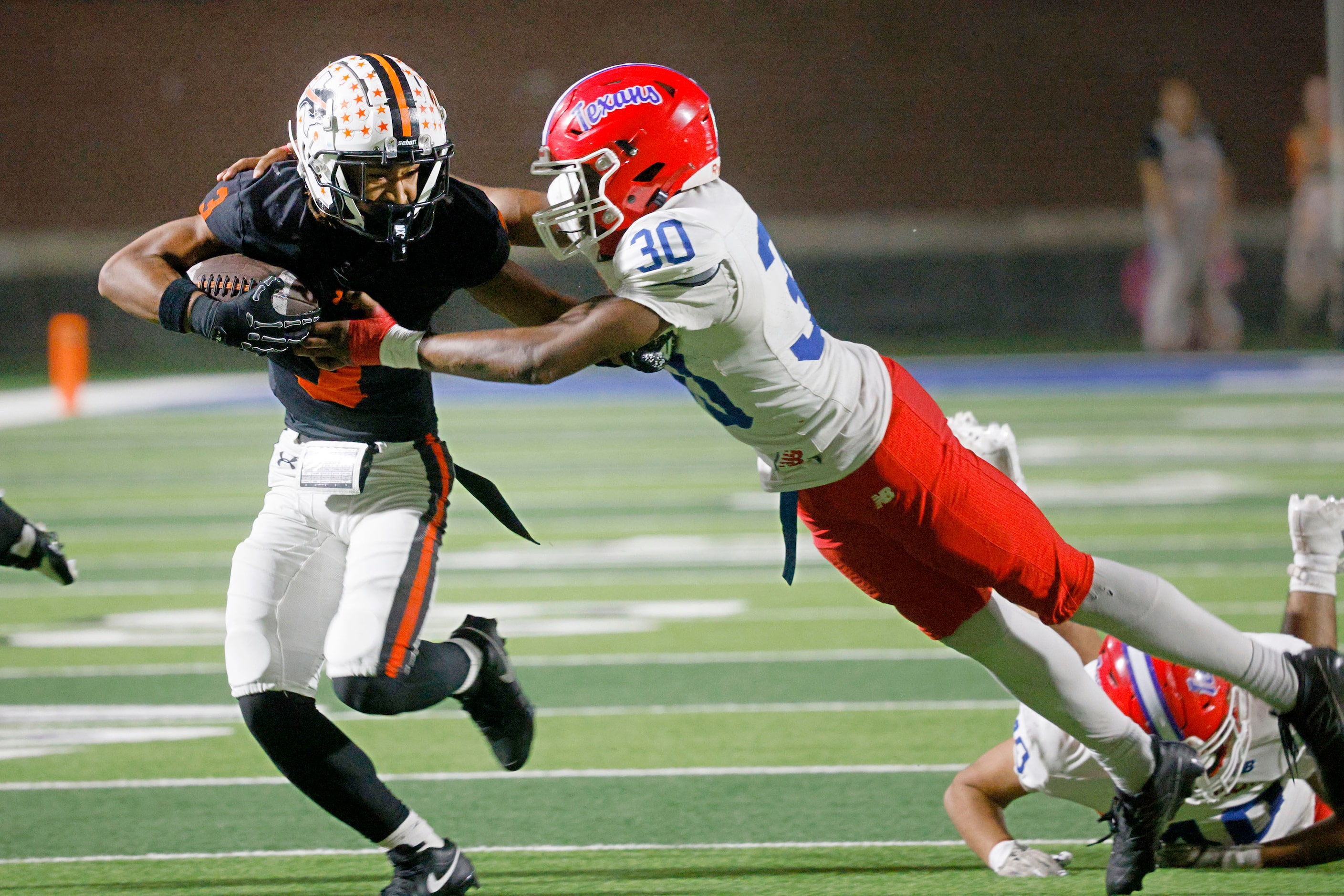 Haltom's Keenan Jackson (3) keeps the ball away from Sam Houston's Jayden Scurlock (30) in...