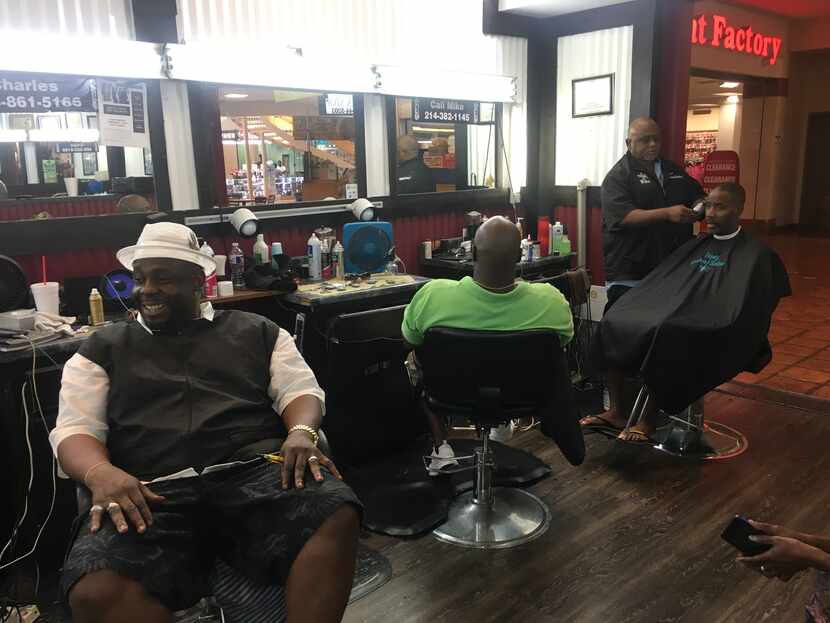 Men hang out at Trendz Barber Shop in Southwest Center Mall, discussing Thursday's protest...