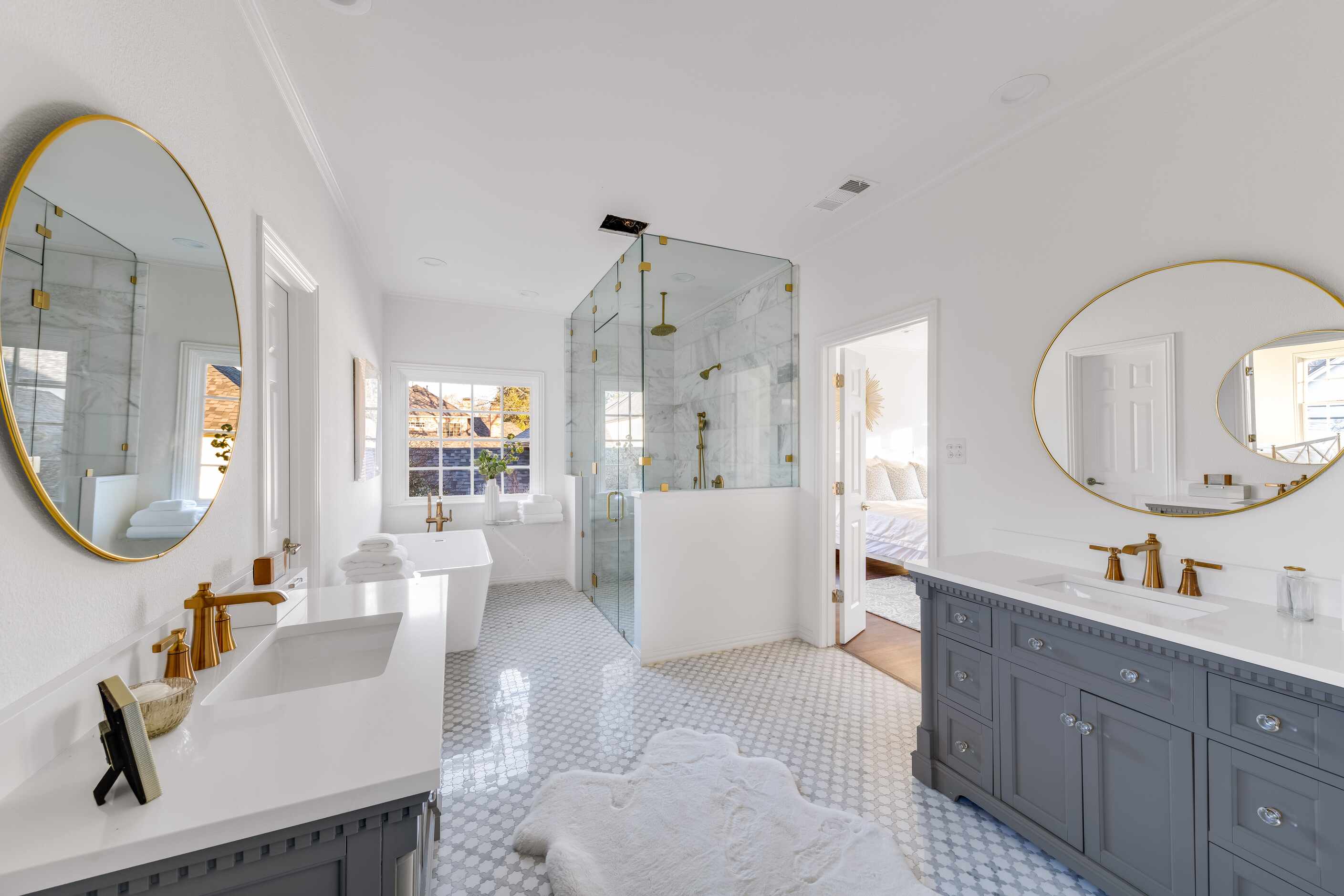 The primary bathroom features a large shower with glass doors and a large soaking tub.